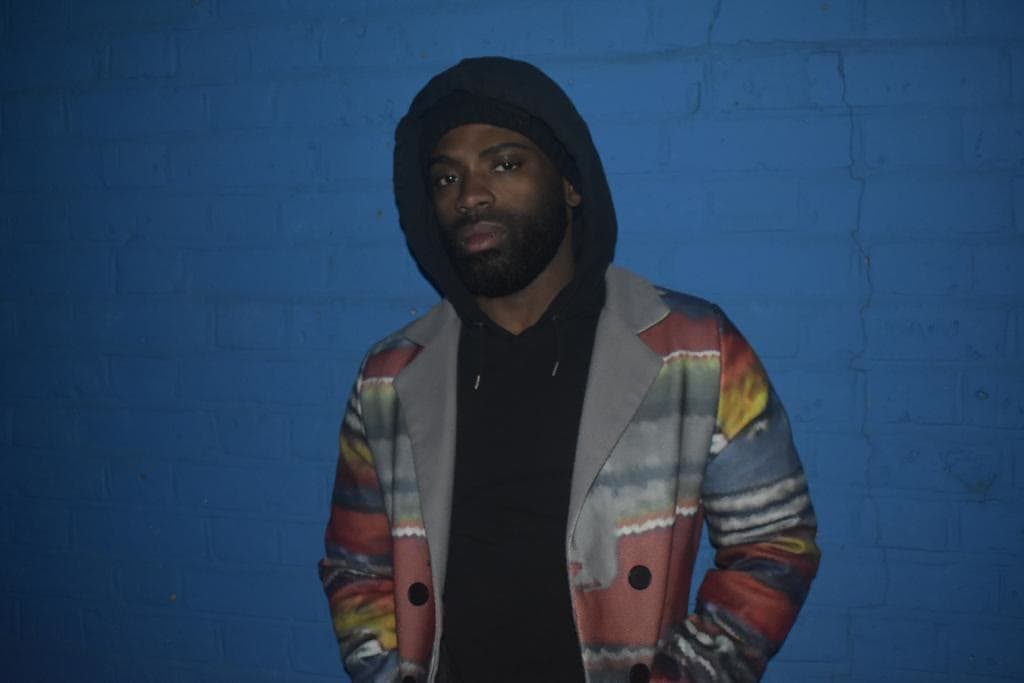 Doja '3reeD' Sowunmi against a blue wall