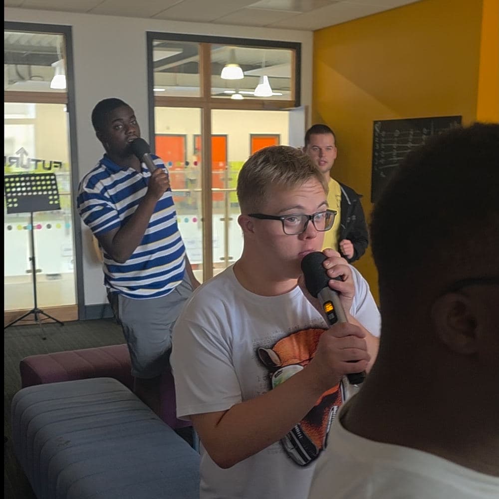 Learners rapping into microphones at Future Youth Zone