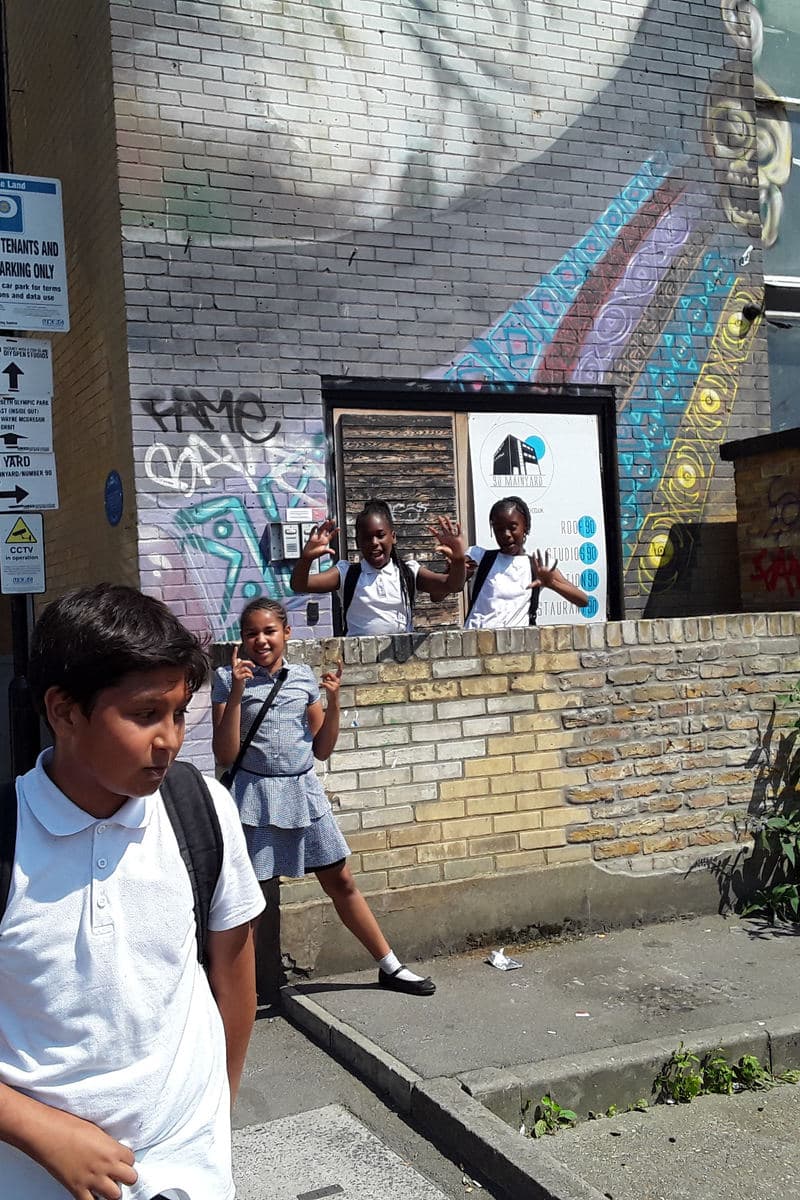 Learners outside the studio by a graffiti wall