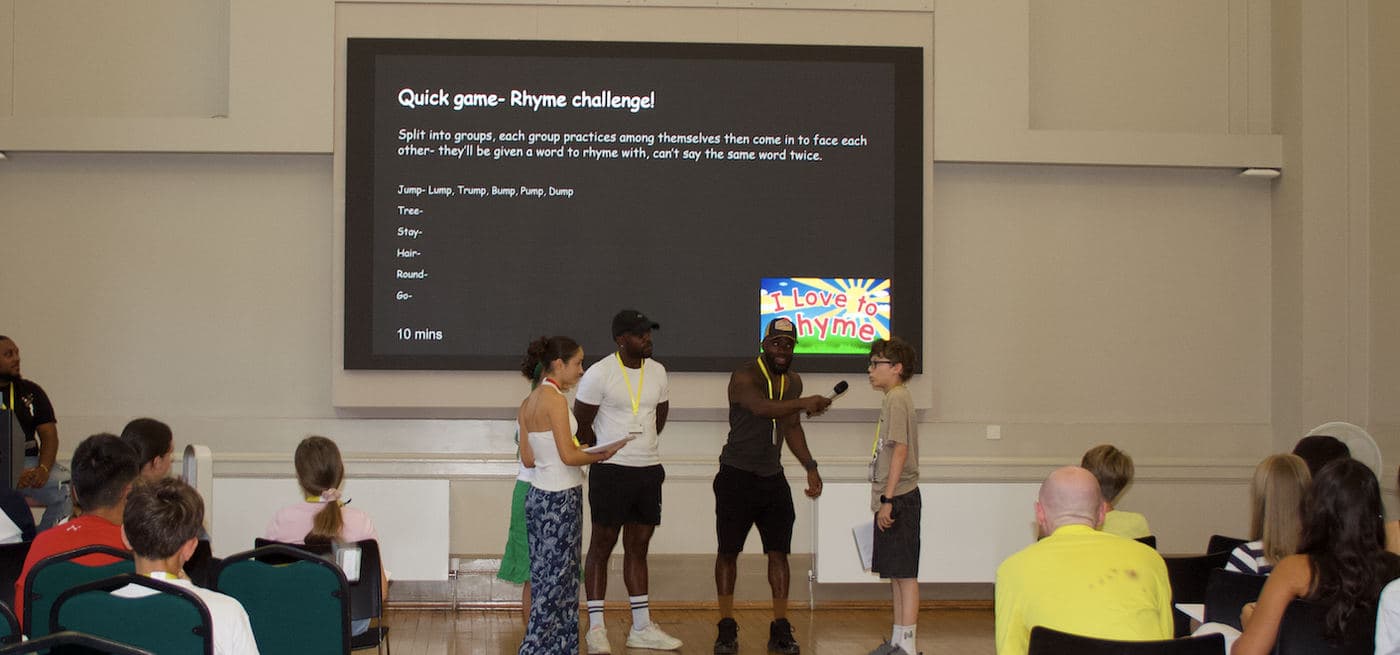 A workshop hall with a rhyme challenge game on screen